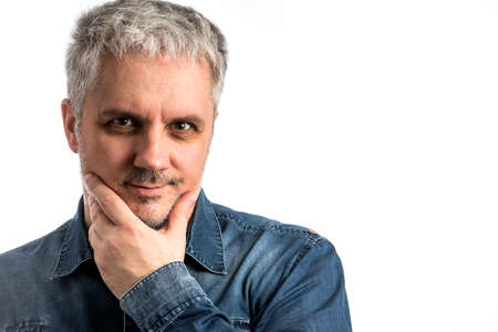 Middle age man in blue jeans shirt with pondering thinking thoughtful expression - isolated on white backgroundの写真素材