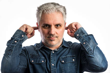 Middle age man in blue jeans shirt playing hear no evil - isolated on white background with clipping path includedの写真素材
