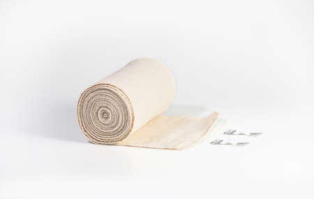 Woven elastic medical bandage rolled into roll and fixation clips. Compression Bandage on a white backgroundの写真素材