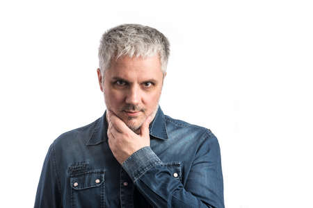 Middle age man in blue jeans shirt with pondering thinking thoughtful expression - isolated on white...