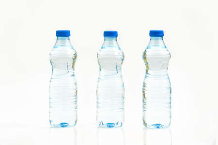Bottled water isolated over a white background - three plastic bottles of waterの写真素材