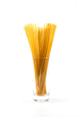 Long spaghetti in a large glass, on white background. selective focus, close-up.の写真素材