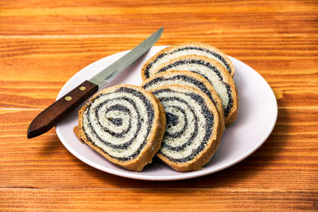 Homemade Poppy seeds pie on old wooden table - side view, dessert and decoration for Christmas, rolled up traditional poppy pieの写真素材