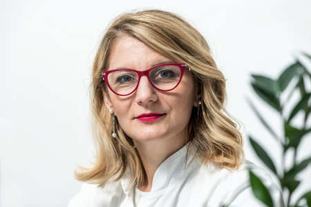 Blonde female physician doctor standing in Her office. Portrait of friendly smiling woman-physician. Medicine conceptの写真素材