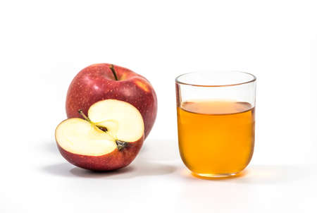 Close up of a glass of apple juice, with a whole and half apple. Natural apple juice on white...