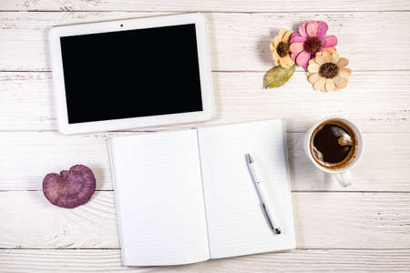 A Notebook copy space mockup photograph styled in a Tablet and coffee setting, on a wooden surfaceの写真素材