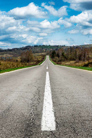 Straight rural road at bright blue day. Vlasina lake landscape countrysideの写真素材