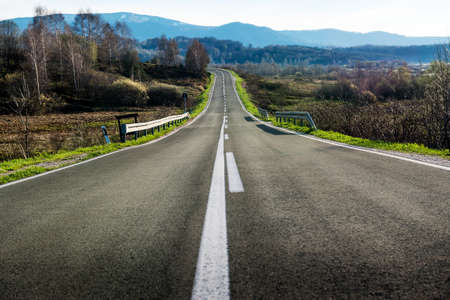 Straight rural road at bright blue day. Countryside landscapeの写真素材