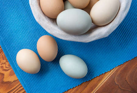 Fresh Chicken and duck eggs collect from farm products natural on a blue cloth background - healthy eating concep. Top Viewの写真素材