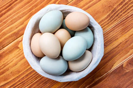 Fresh Chicken and duck eggs collect from farm products natural on a wooden table. Healthy eating concept - Top Viewの写真素材