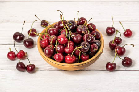 Bowl full of ripe red dark cherries on wooden table surface as Source of vitamins, organic foodの写真素材