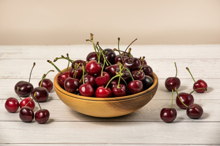Bowl full of ripe red dark cherries on wooden table surface as Source of vitamins, organic foodの写真素材