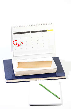 Learning for exam concept with Mark on the calendar - Red circle marking Exam date on calendar sheet on top of books and notebook with pencilの写真素材