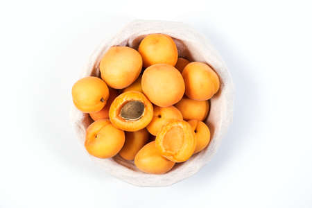 Ripe apricots on the table. Orange apricots fruits in a basket. Juicy apricots nutrition. Top Viewの写真素材