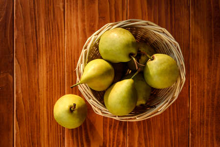 Healthy Organic Pears in the Basket on wooden rustic background. Fresh pears from the farm. Healthy food full of vitamins. Top Viewの写真素材