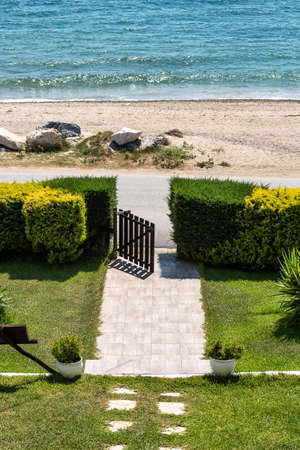 Front lawn and Garden with wooden gate located by the seaの写真素材