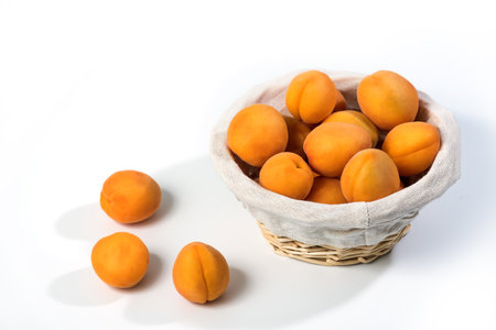Ripe apricots on the table. Orange apricots fruits in a basket. Juicy apricots nutritionの写真素材
