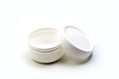 Empty White Plastic opaque cream jar with lid. Isolated on white background. Cosmetic product for...