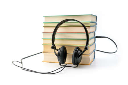 Stack of books with the earphones. Audiobooks. Listen and study conceptの写真素材