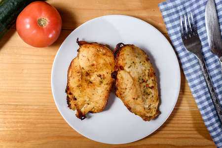 Grilled and herbed chicken breast fillet served with tomato and cucumber. Delicious Fried Breaded 

chicken steak. Top Viewの写真素材