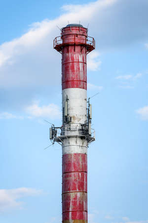 White and red chimney on a background of blue sky. Power plant chimneyの写真素材