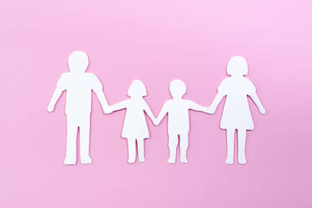 Paper family cut out on bright pink background. Family home, foster care, family mental health, divorce and family crisis conceptの写真素材