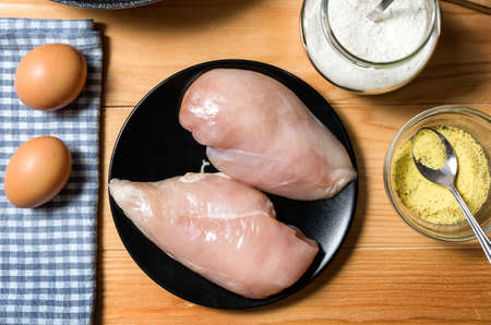 Chicken fillet in a black plate ready for grilling. Chicken steaks for cooking. Top viewの写真素材