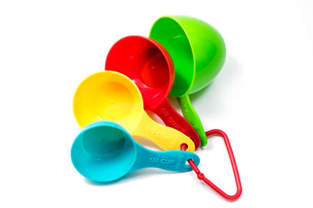 Four pieces of colorful ingredient measuring scoops or spoons of different cup sizes connected together. Isolated on white background with Clipping pathの写真素材