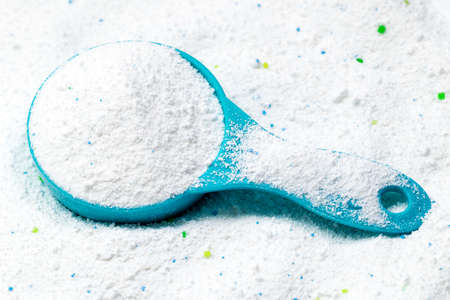 Blue cup or scoop of white powder Detergent for clothes washing. Top view.の写真素材