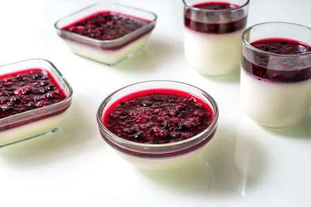 Delicious panna cotta with with raspberry sauce on white tableの写真素材
