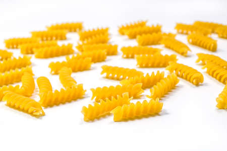 Raw Fusilli pasta, isolated on white background, selective focus. Italian pastaの写真素材