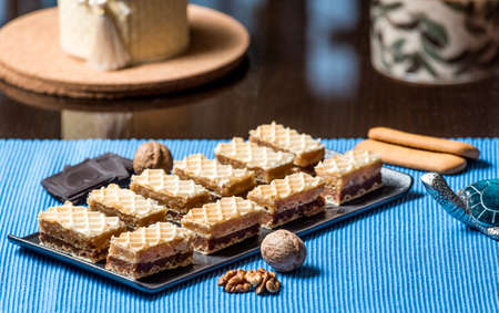 Homemade caramel and chocolate waffer dessert in a black service plateの写真素材