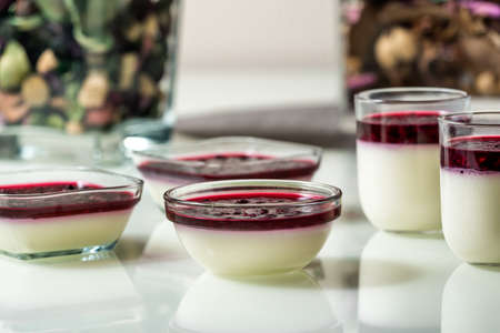 Delicious panna cotta with with raspberry sauce on white tableの写真素材