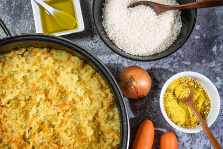 Italian vegan Risotto in a large pan with ingredients - rice, onion, carrots, spices, olive oilの写真素材