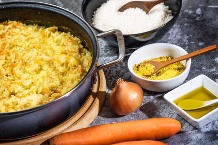 Italian vegan Risotto in a large pan with ingredients - rice, onion, carrots, spices, olive oilの写真素材