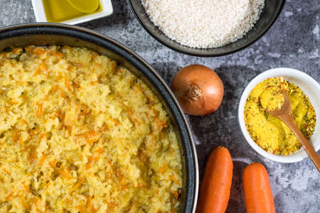 Italian vegan Risotto in a large pan with ingredients - rice, onion, carrots, spices, olive oilの写真素材