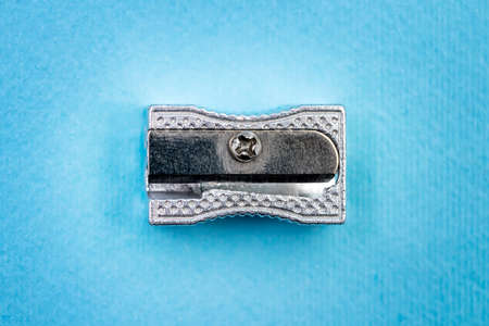 Metallic pencil sharpener on blue background. School concept. Top Viewの写真素材