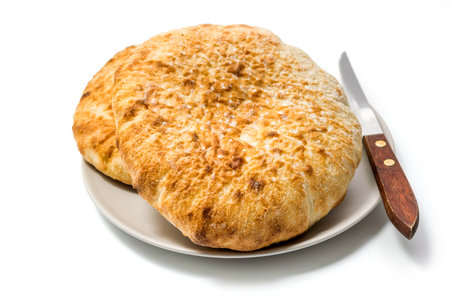 Loafs of flat round wheat bread in a plate isolated on white background with clipping pathの写真素材