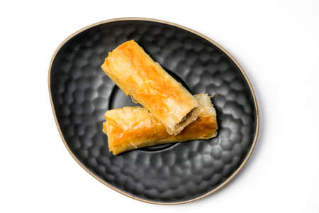 Meat rolls pastry - fried minced pork meat in spring rolls in a black oval plate, isolated on white background with clipping path included. Top Viewの写真素材