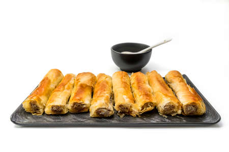 Meat rolls pastry - fried minced pork meat in spring rolls in a serving plate with a bowl of tartar sauce, isolated on white background with clipping path includedの写真素材