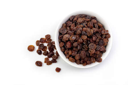 Brown raisins in white bowl isolated on white backgroundの写真素材