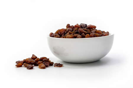 Brown raisins in white bowl isolated on white backgroundの写真素材