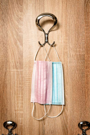 Protective surgical face masks on anteroom coat hanger stand during covid-19 pandemics