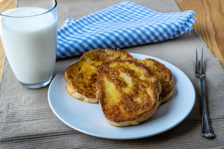 French toast - Przenice - slices of bread soaked in beaten eggs and milk and fried, with a glas of yogurt on a wooden table. Eggy bread, Bombay toast, German toast, gypsy toast or poor knightslesの写真素材