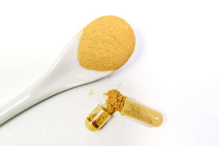 Capsules with bio additives. Tablets and capsules as a treatment of a disease. Capsule with natural supplements on white table background. Macro with Selective focusの写真素材