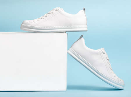 Pair of Stylis New White Sneakers and white box Over light blue Background. Horizontal Imageの写真素材