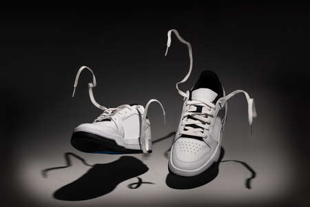 New unbranded tennis shoes flying in the air - shot with studio lighting on white background. New unbranded Sneakers or trainers on white background. Men's sport footwear. Pair of sport shoes.の写真素材