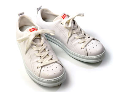 Belgrade, Serbia - May 06, 2022. Pair of Stylis New White Camper Sneakers Over White Background. Horizontal Imageのeditorial素材