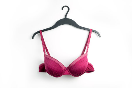 Female pink bra on a hanger, white backgroundの写真素材