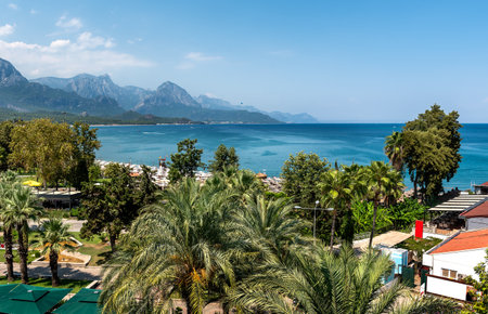 Sunshades and chaise lounges on beach. Turkey, Kemer. Beautiful view of mountains and sea from embankmentの写真素材